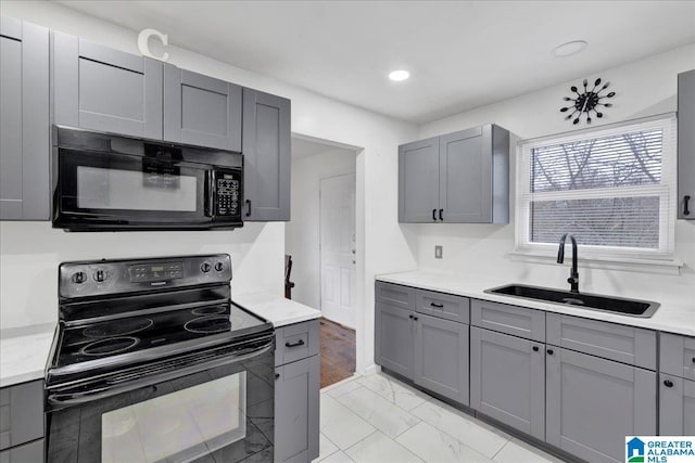 kitchen featuring gray cabinetry, sink, and black appliances