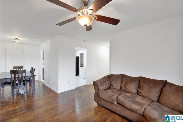 living room featuring dark wood-type flooring and ceiling fan