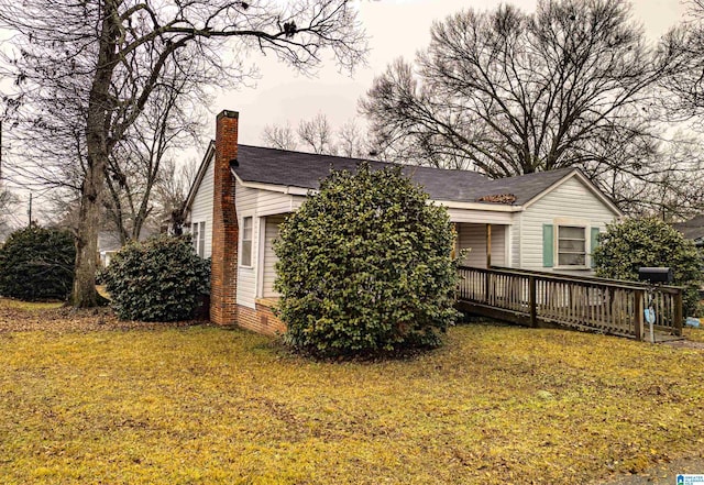 view of home's exterior featuring a wooden deck and a yard