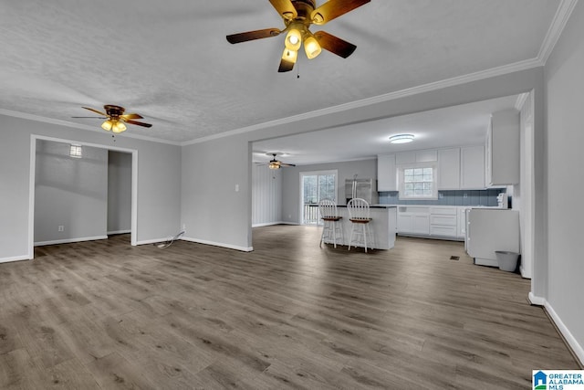 unfurnished living room featuring hardwood / wood-style flooring and ornamental molding