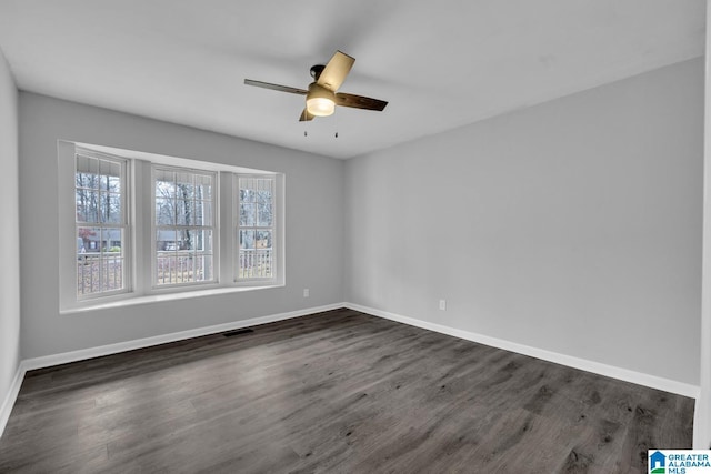 empty room featuring dark wood-type flooring and ceiling fan