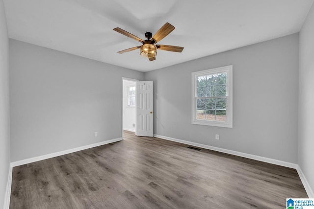 empty room with hardwood / wood-style floors and ceiling fan