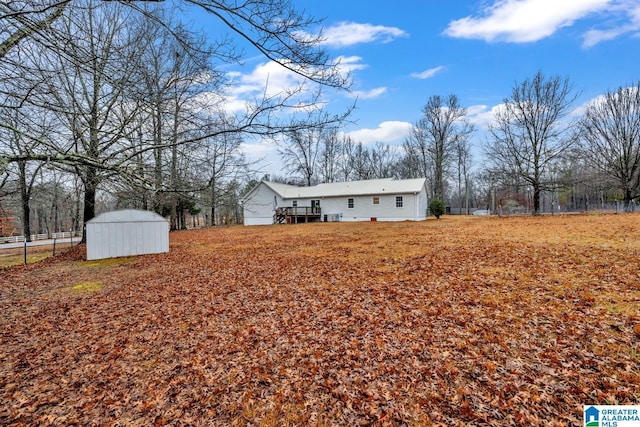 view of yard featuring a deck and a storage shed