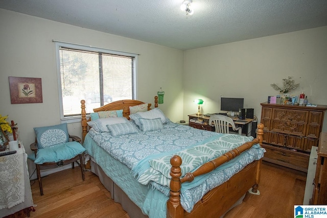 bedroom featuring wood-type flooring and a textured ceiling