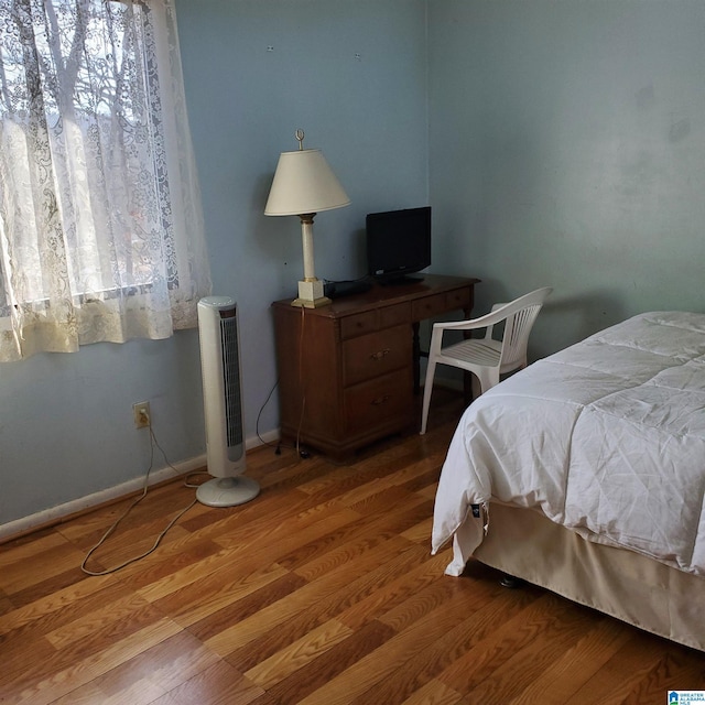 bedroom with wood-type flooring and multiple windows