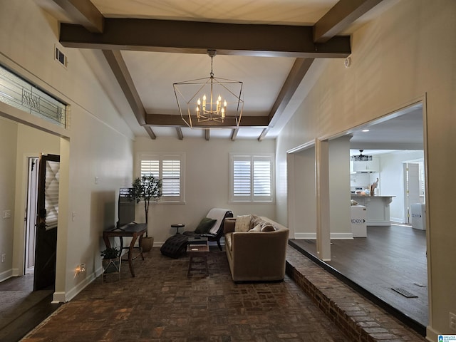 sitting room with beamed ceiling and a notable chandelier