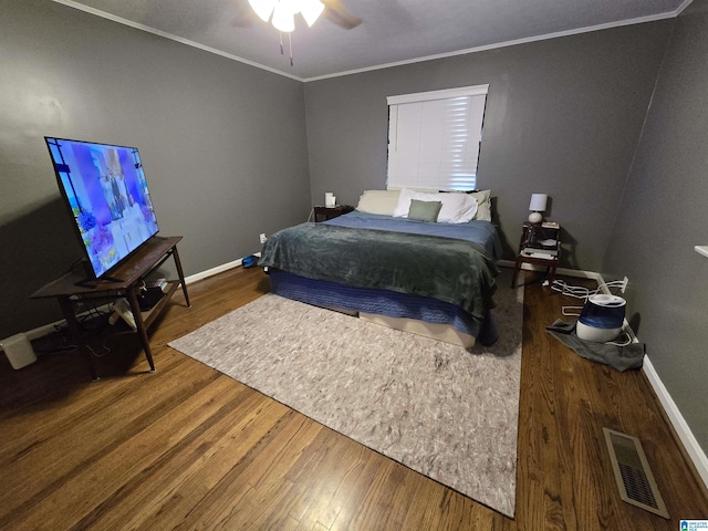 bedroom featuring hardwood / wood-style flooring, crown molding, and ceiling fan