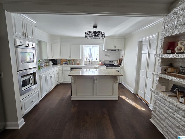 kitchen with sink, tasteful backsplash, appliances with stainless steel finishes, a kitchen island, and white cabinets