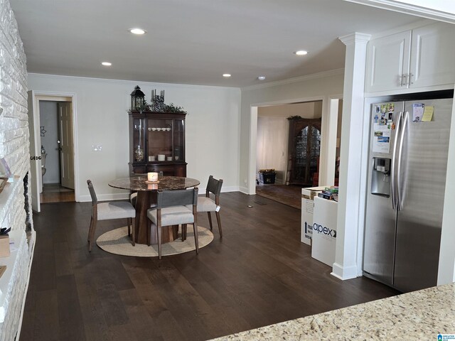 dining room with ornamental molding and dark hardwood / wood-style flooring