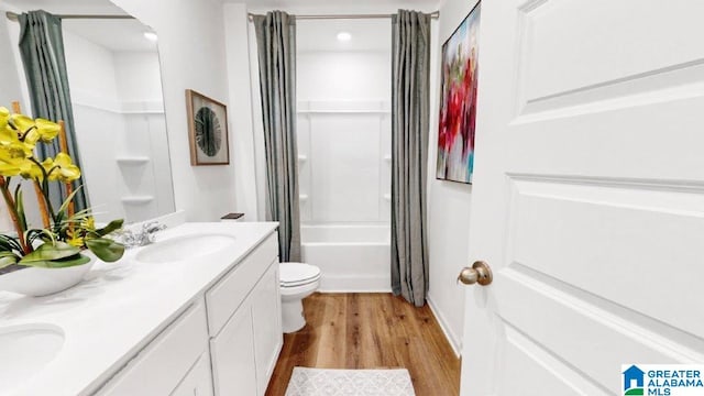 full bathroom with shower / bathtub combination with curtain, vanity, hardwood / wood-style flooring, and toilet