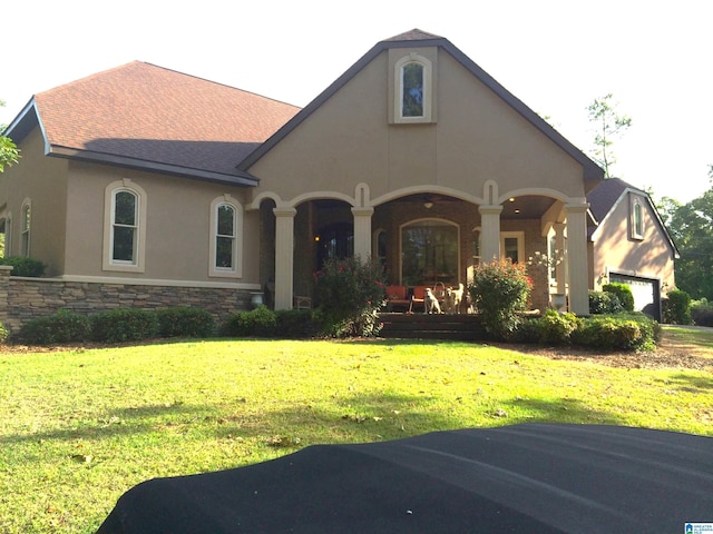 view of front of house with a garage, a front yard, and covered porch