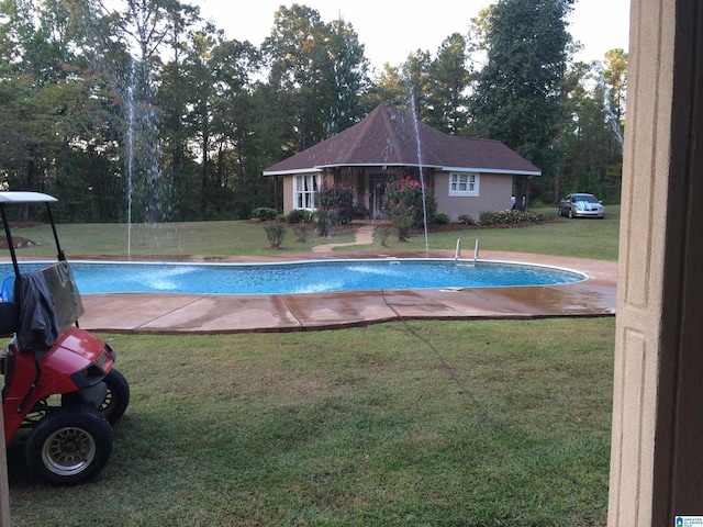 view of swimming pool featuring a yard