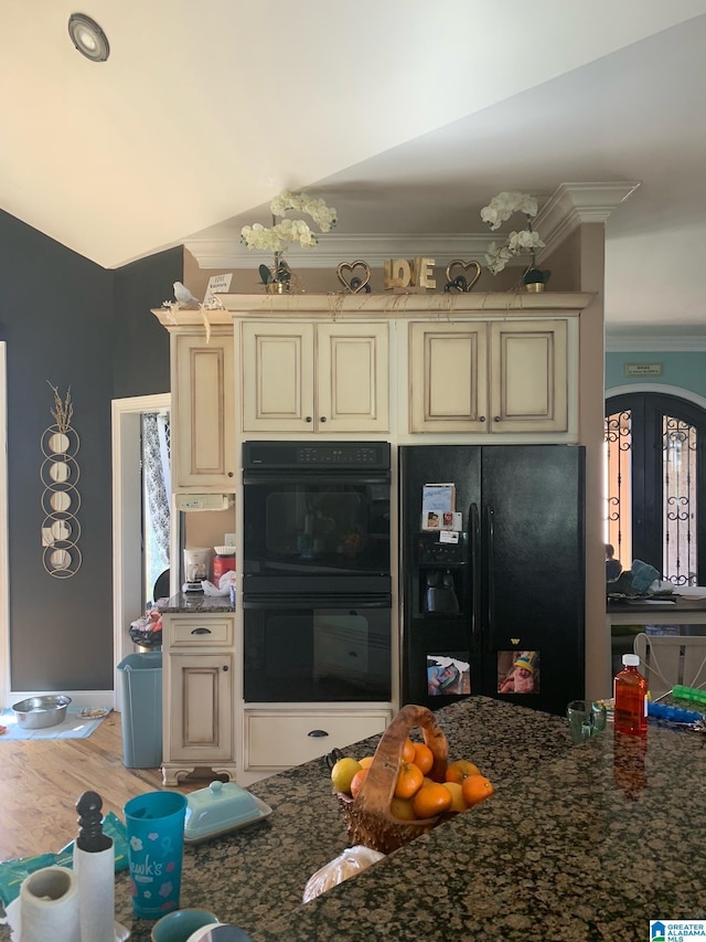 kitchen featuring lofted ceiling, crown molding, wood-type flooring, black appliances, and cream cabinetry