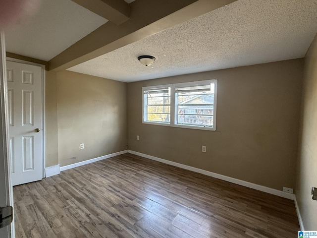 spare room with wood-type flooring and a textured ceiling