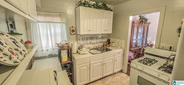 kitchen with white cabinetry, white range with gas cooktop, and sink