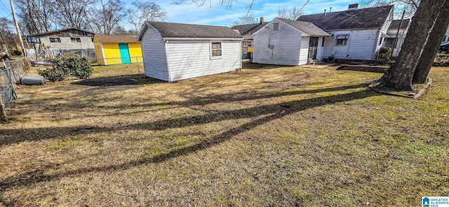 rear view of property featuring a storage shed and a yard