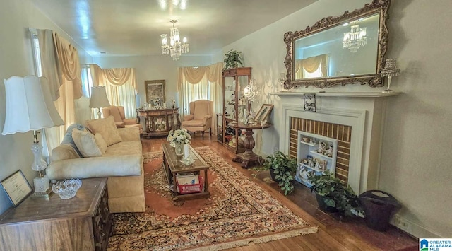 living room with an inviting chandelier, wood-type flooring, and a brick fireplace