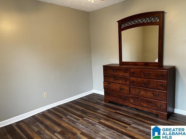 unfurnished bedroom featuring dark hardwood / wood-style flooring and a textured ceiling