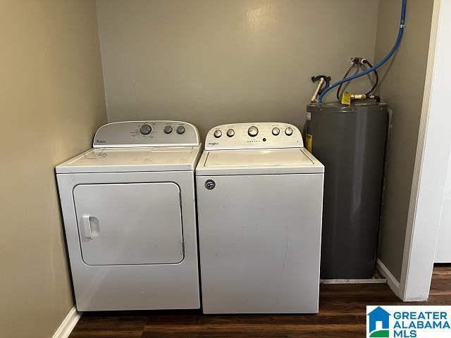 laundry room featuring separate washer and dryer, dark hardwood / wood-style floors, and water heater