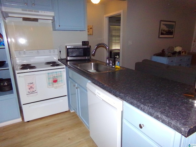 kitchen featuring white appliances, under cabinet range hood, light wood-style floors, and a sink