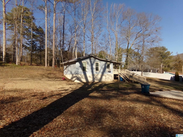 view of home's exterior featuring stairway and fence