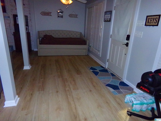 interior space with decorative columns, baseboards, and wood finished floors