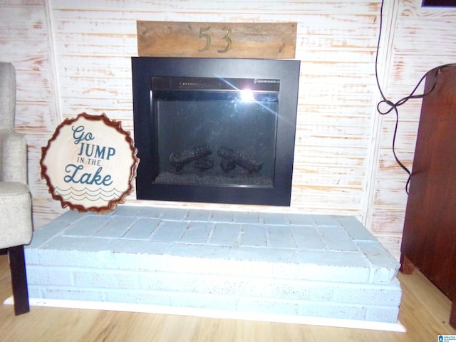 details with a fireplace with raised hearth and wood finished floors