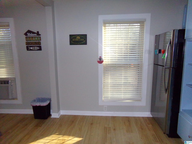 unfurnished dining area with a wealth of natural light, light wood-type flooring, and baseboards