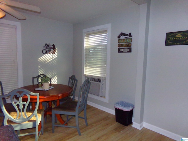 dining area with light wood finished floors, ceiling fan, baseboards, and cooling unit