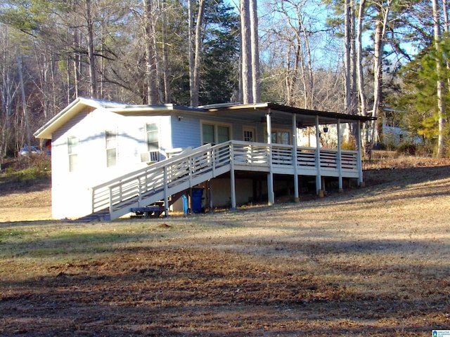 view of front facade with a front lawn and a wooden deck