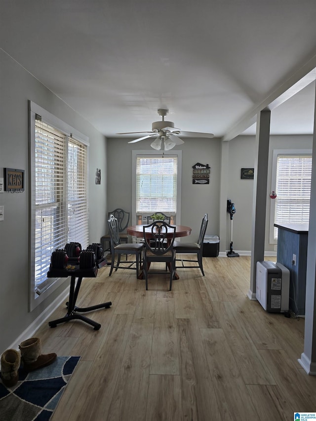 unfurnished dining area with ceiling fan, wood finished floors, and baseboards