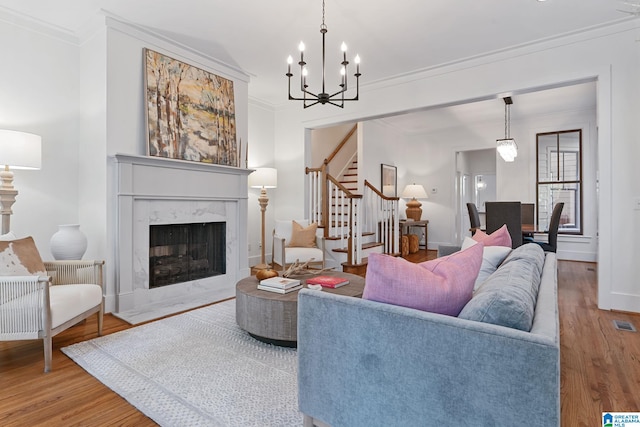 living room with hardwood / wood-style flooring, a premium fireplace, and crown molding