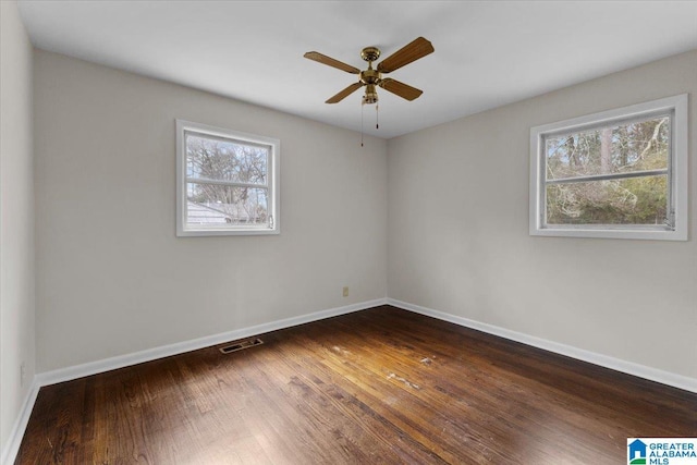 spare room featuring dark hardwood / wood-style flooring and ceiling fan