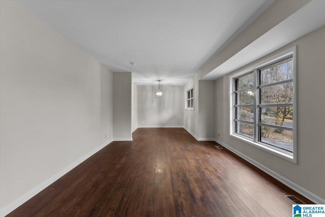 unfurnished room featuring dark wood-type flooring and plenty of natural light