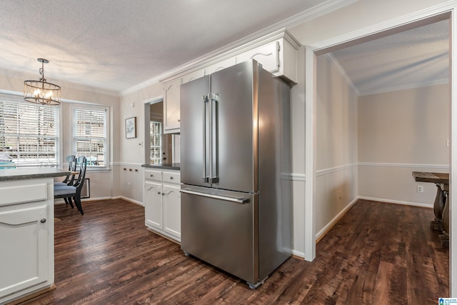 kitchen with dark hardwood / wood-style flooring, white cabinets, stainless steel refrigerator, and decorative light fixtures