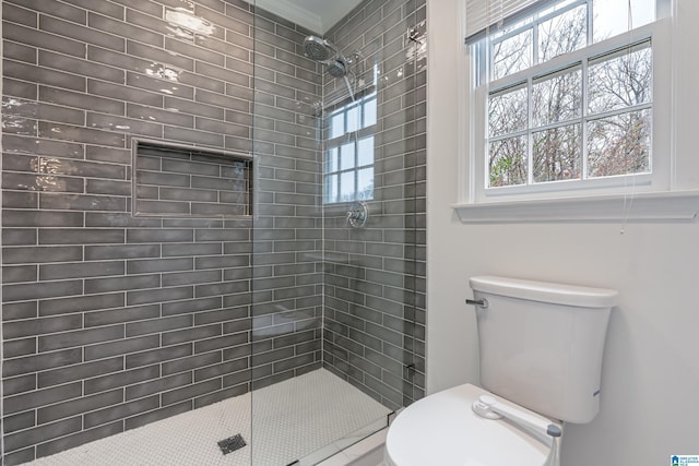 bathroom with tiled shower and toilet