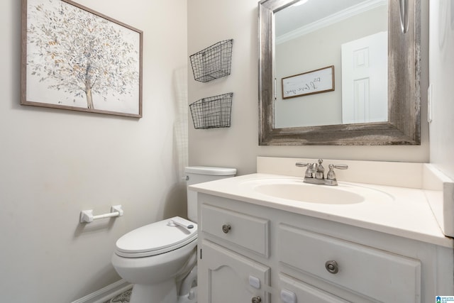 bathroom with vanity, crown molding, and toilet