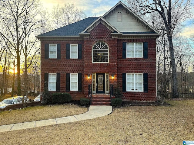 colonial inspired home with a lawn