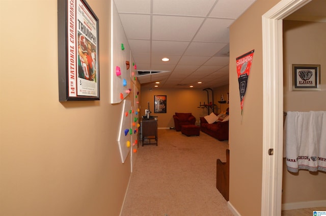 hallway with light carpet and a drop ceiling