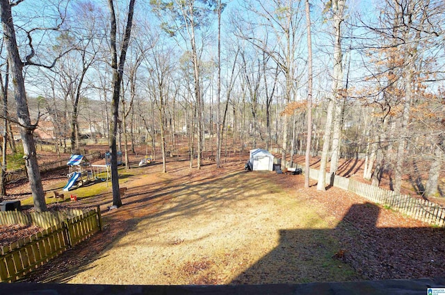 view of yard featuring a playground and a storage unit