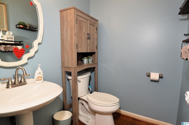 bathroom featuring hardwood / wood-style flooring, sink, and toilet