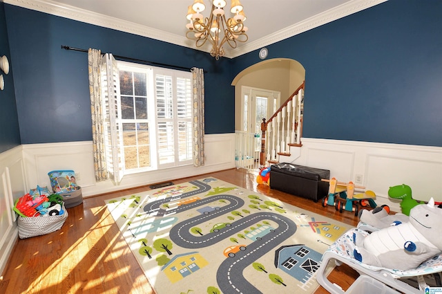 rec room featuring ornamental molding, hardwood / wood-style floors, and a chandelier