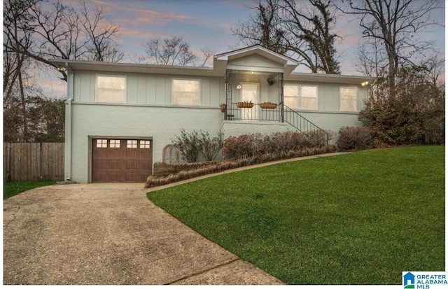 ranch-style home with a garage and a yard