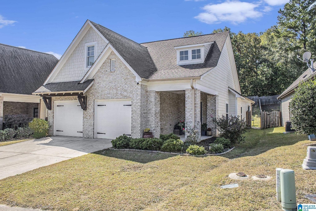 view of front of house with cooling unit, a garage, and a front lawn