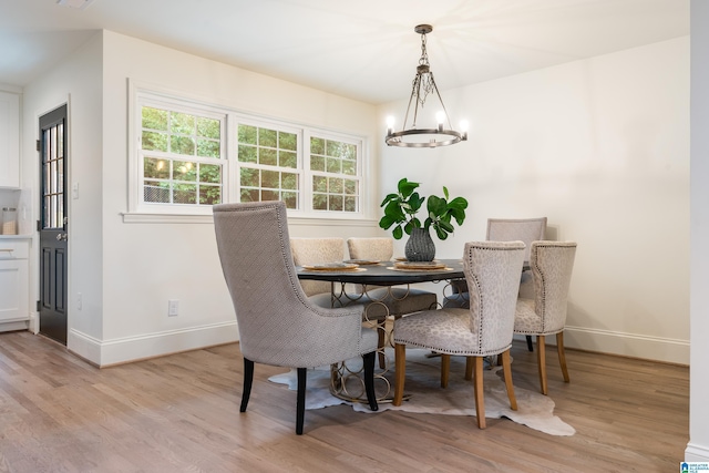 dining room with an inviting chandelier and light hardwood / wood-style flooring