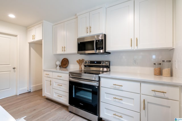 kitchen with white cabinetry, appliances with stainless steel finishes, tasteful backsplash, and light hardwood / wood-style flooring