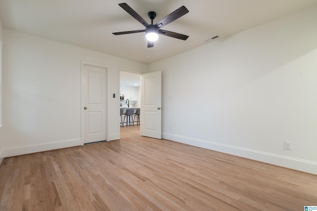 unfurnished room with ceiling fan, sink, and light hardwood / wood-style flooring