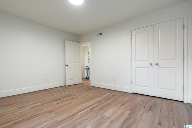 unfurnished bedroom featuring a closet and light hardwood / wood-style flooring