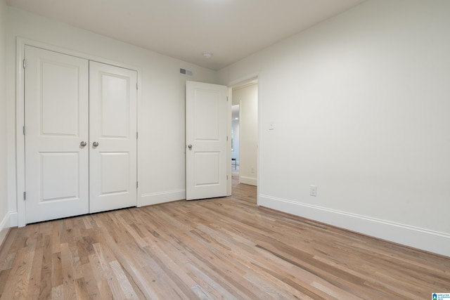 unfurnished bedroom with light hardwood / wood-style floors and a closet