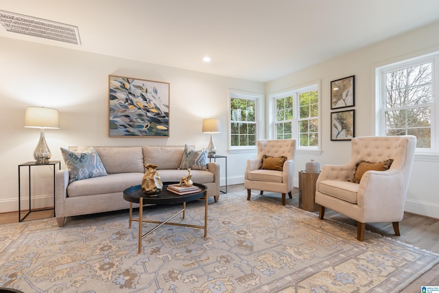 living room with a healthy amount of sunlight and light hardwood / wood-style flooring